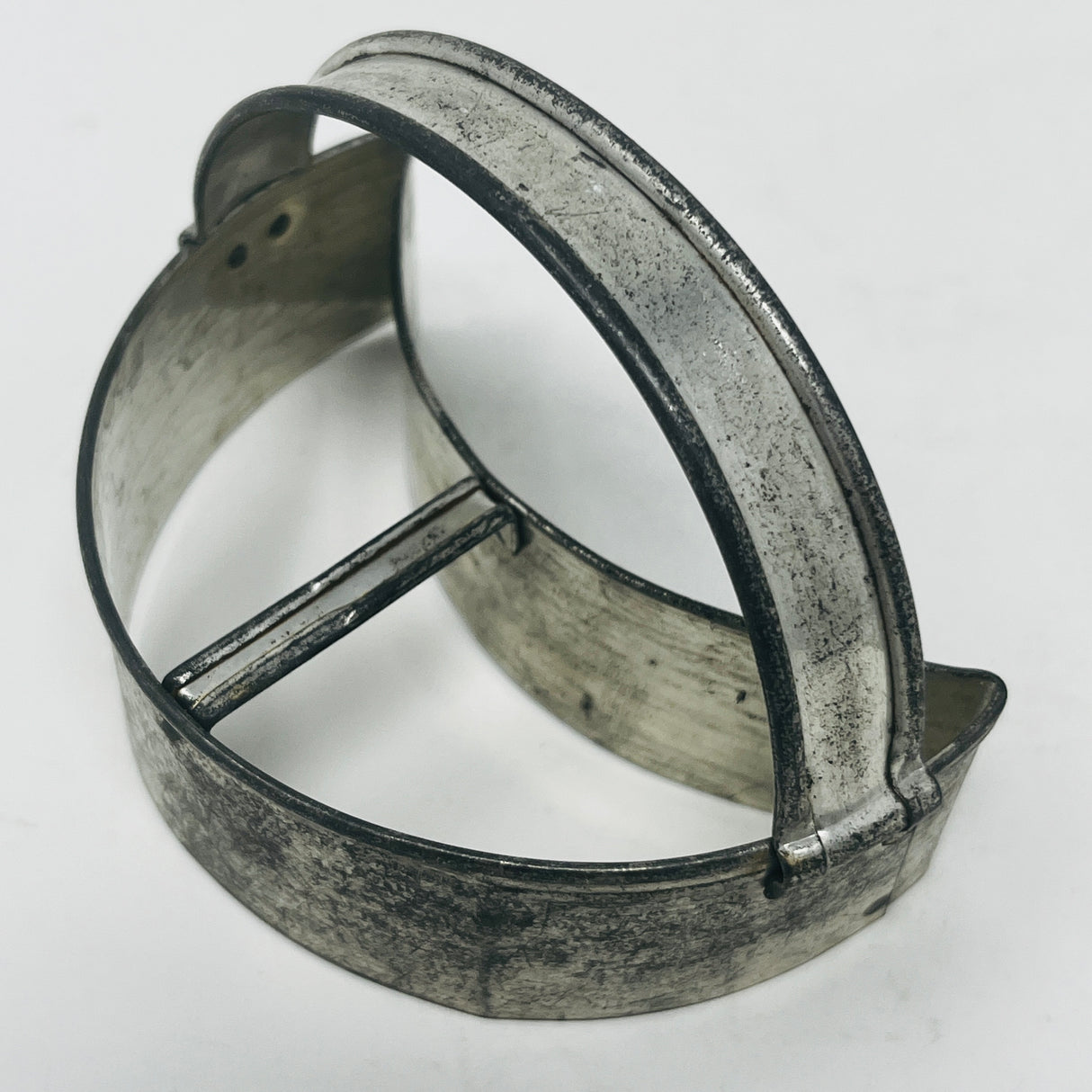 Mid-century metal cookie cutter with a circular shape and large handle, designed for easy grip, reflecting 1930s style.