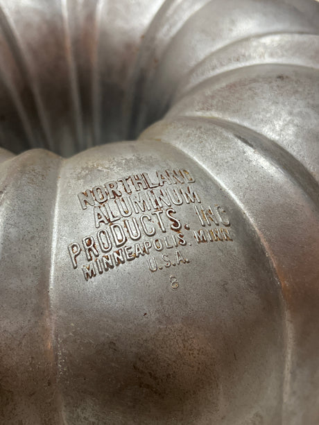 Northland Aluminum Products Inc., Original Bundt Cake pan (vintage Nordic Ware), featuring a fluted design and maker's mark, showcasing its heavy-duty, collector-worthy 1950s craftsmanship.