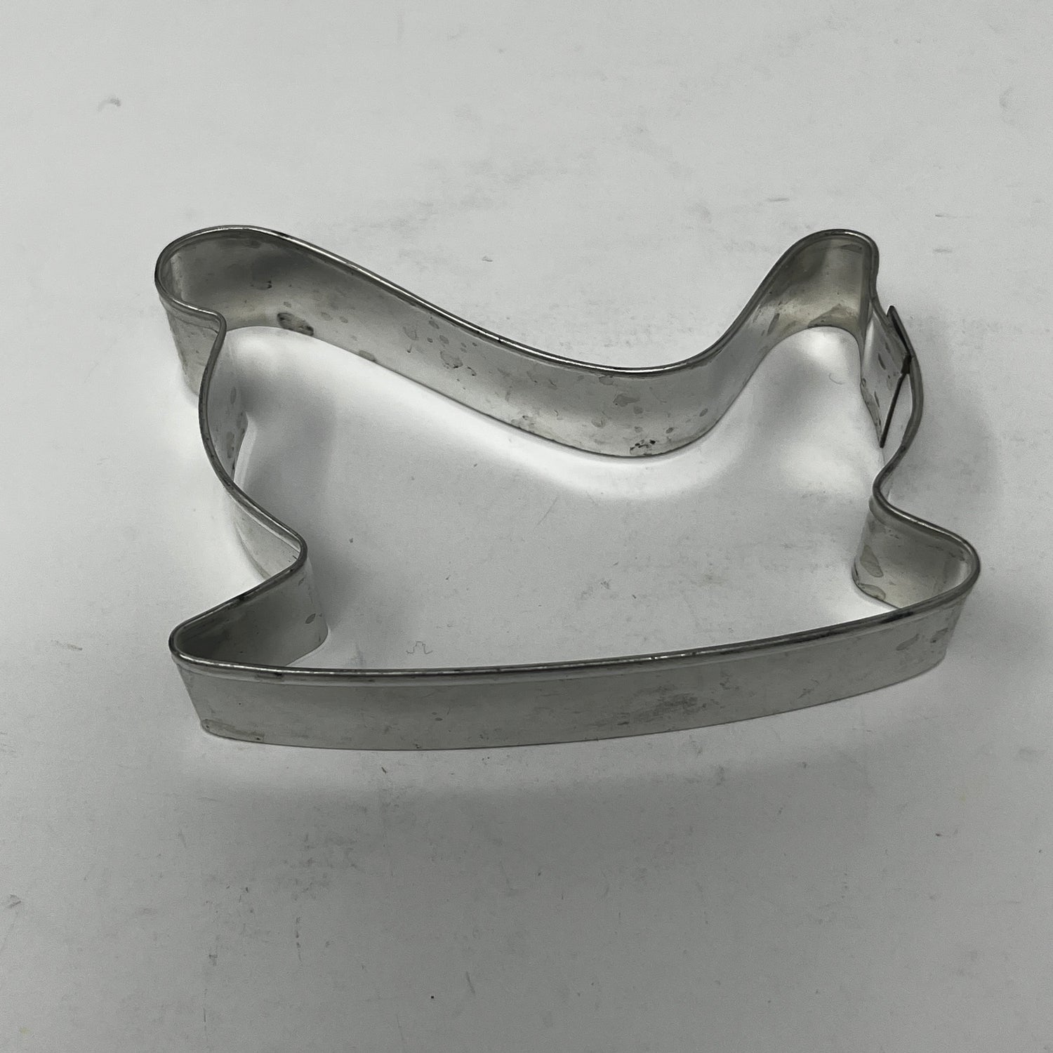 Mid-century metal cookie cutter on a white surface, designed for easy grip with a large handle, ideal for creating unique, collectible shapes.