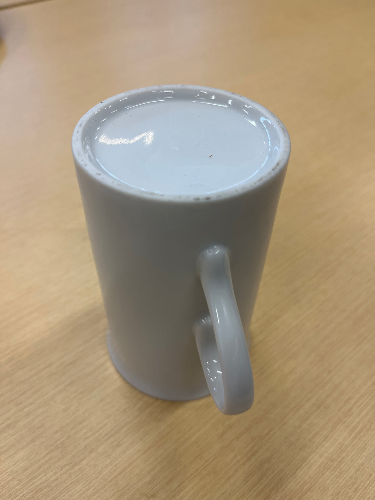 Tall ceramic white coffee mug with a smooth finish and a delicate, offset handle, ideal for everyday use. Elegant and timeless design.