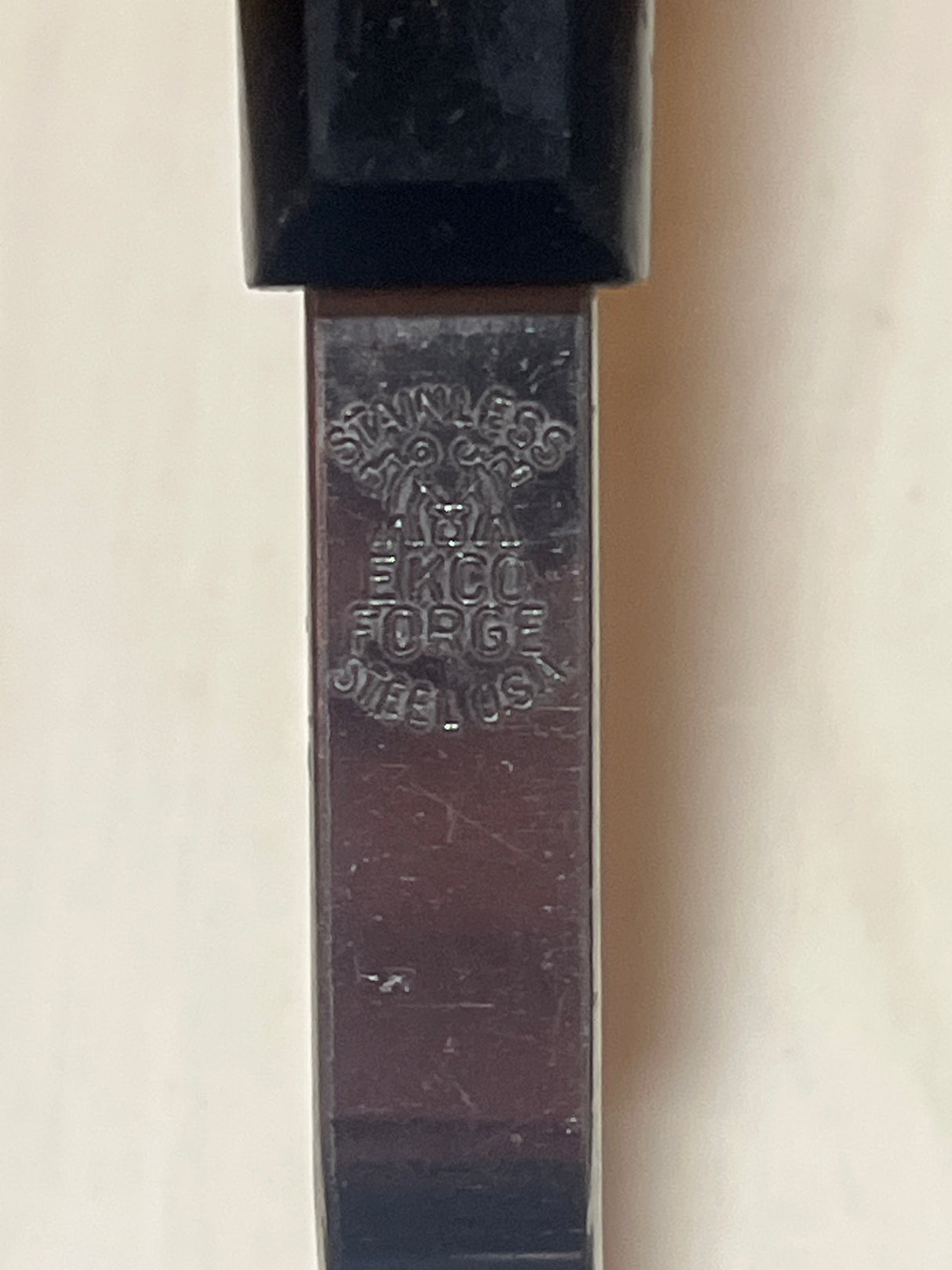 EKCO Flipper Lifter stainless steel spatula with chrome-plated blade showing “STAINLESS,” “FORGED STEEL,” “U.S.A.” maker’s mark below the black plastic handle.