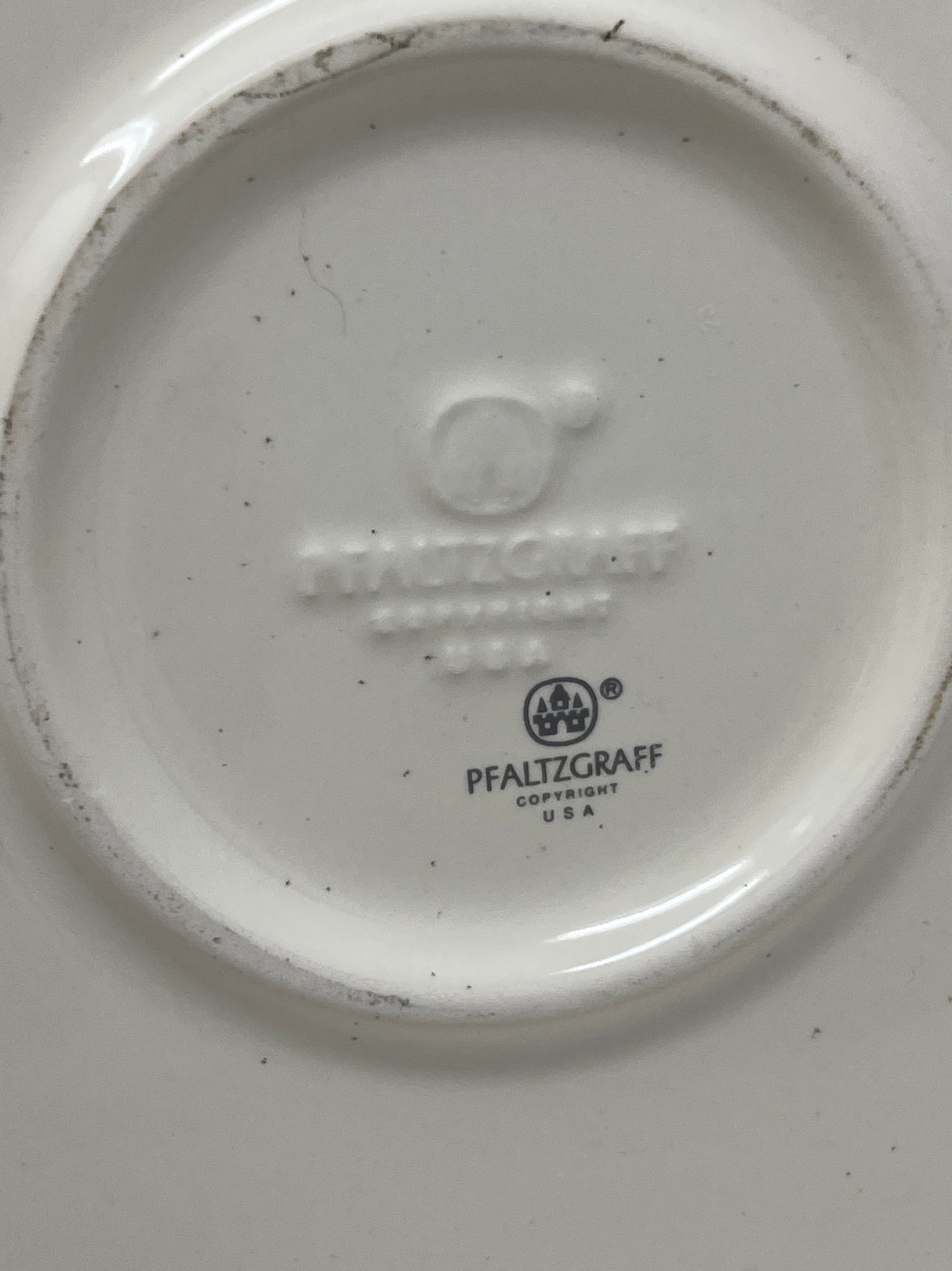 Pfaltzgraff rose motif cake plate with cover, features a white plate adorned with black text and a central black castle logo in a circle.