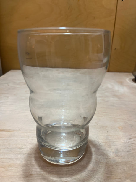 Wavy sided tall drinking glass showcased on a wooden surface, highlighting its double-walled, contoured design for stylish and functional use.