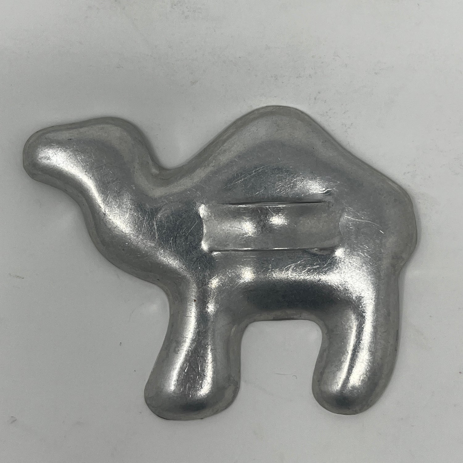 Mid century metal cookie cutter shaped like a camel, showcasing a sturdy design with a large handle for easy gripping.