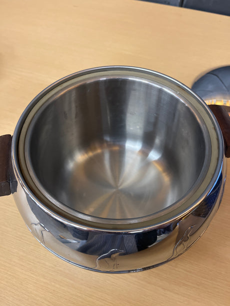 1950s West Bend Penguin steel hot and cold server set with Bakelite handles, featuring an embossed penguin motif, shown as a polished silver bowl and pot.