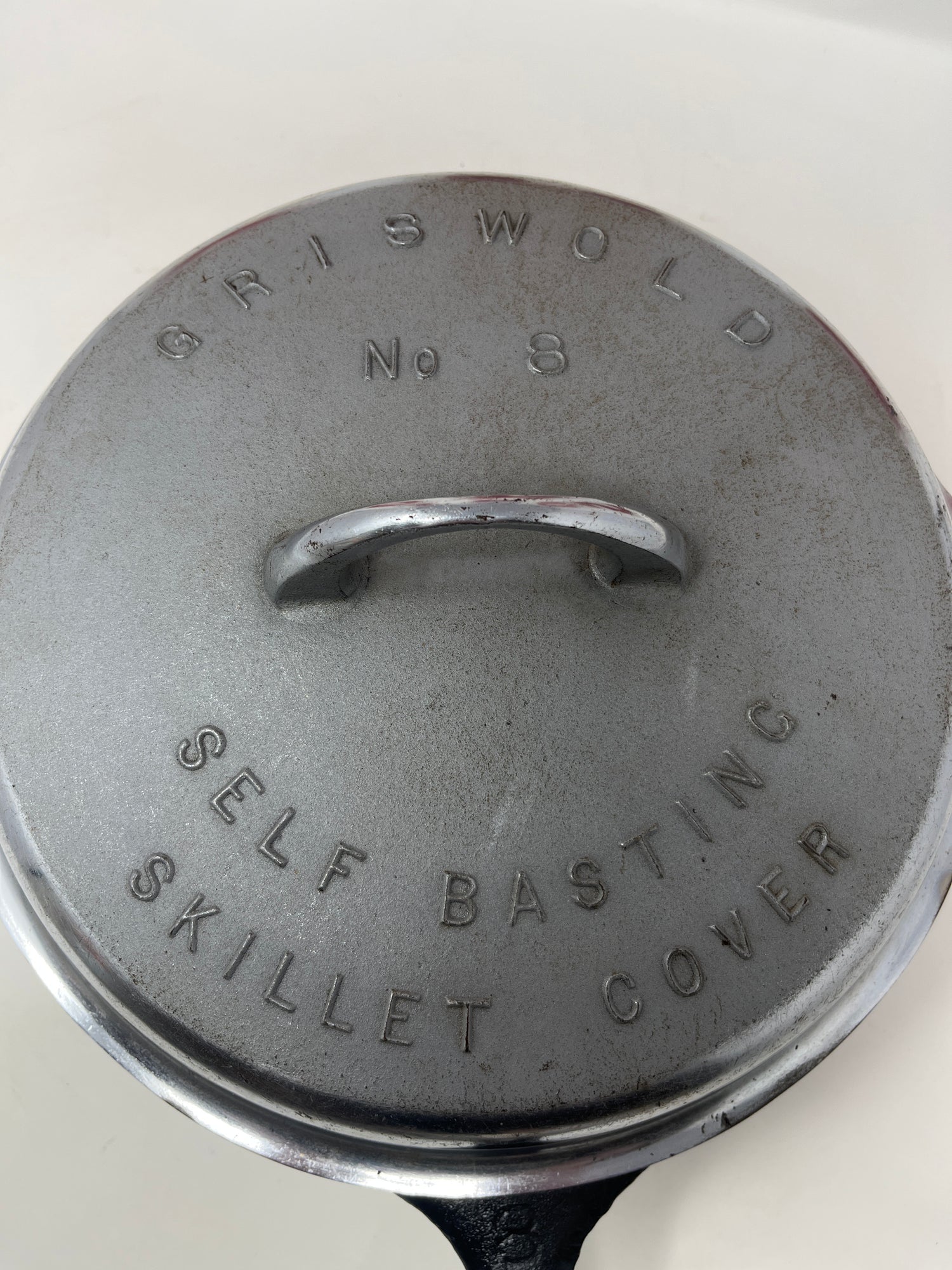 Untitled May22_10:36 showcases a rare 1930s Griswold skillet with lid; features surface wear on lid and uneven seasoning, yet remains in excellent working condition.