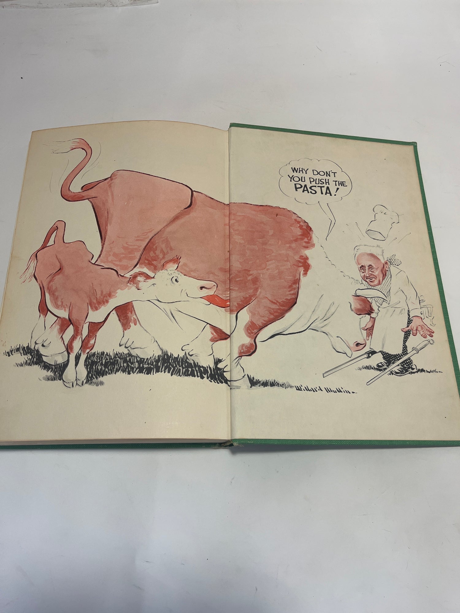 Leone’s Italian Cookbook (1967 First Edition) open, showing a cartoon cow and chef with a pun on “pasture” vs. “pasta,” reflecting its humorous, culinary nature.
