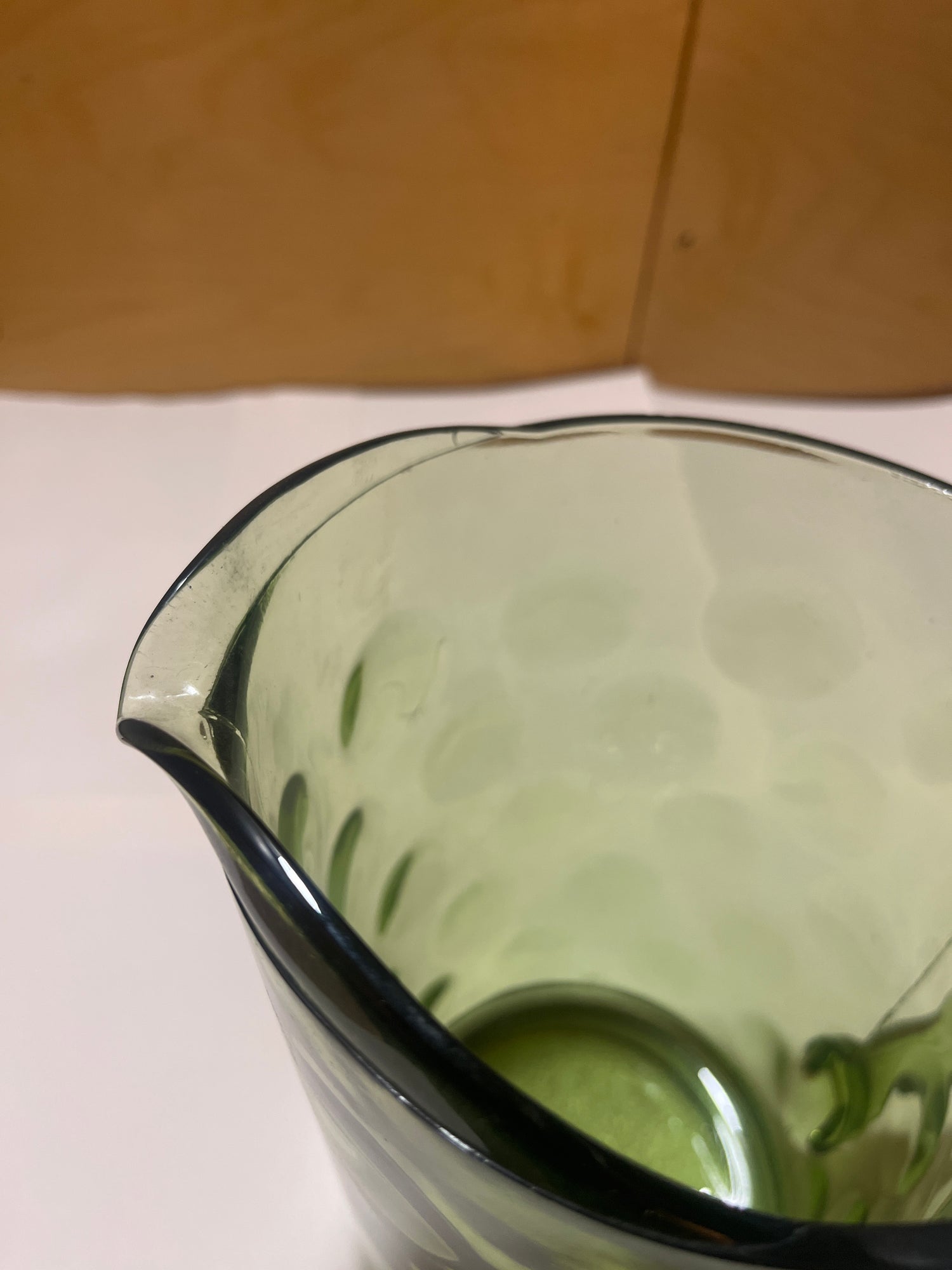 Hazel Atlas Eldorado avocado green coin dot glass pitcher with a flared rim and spout, featuring a translucent design and faint circular indentations.