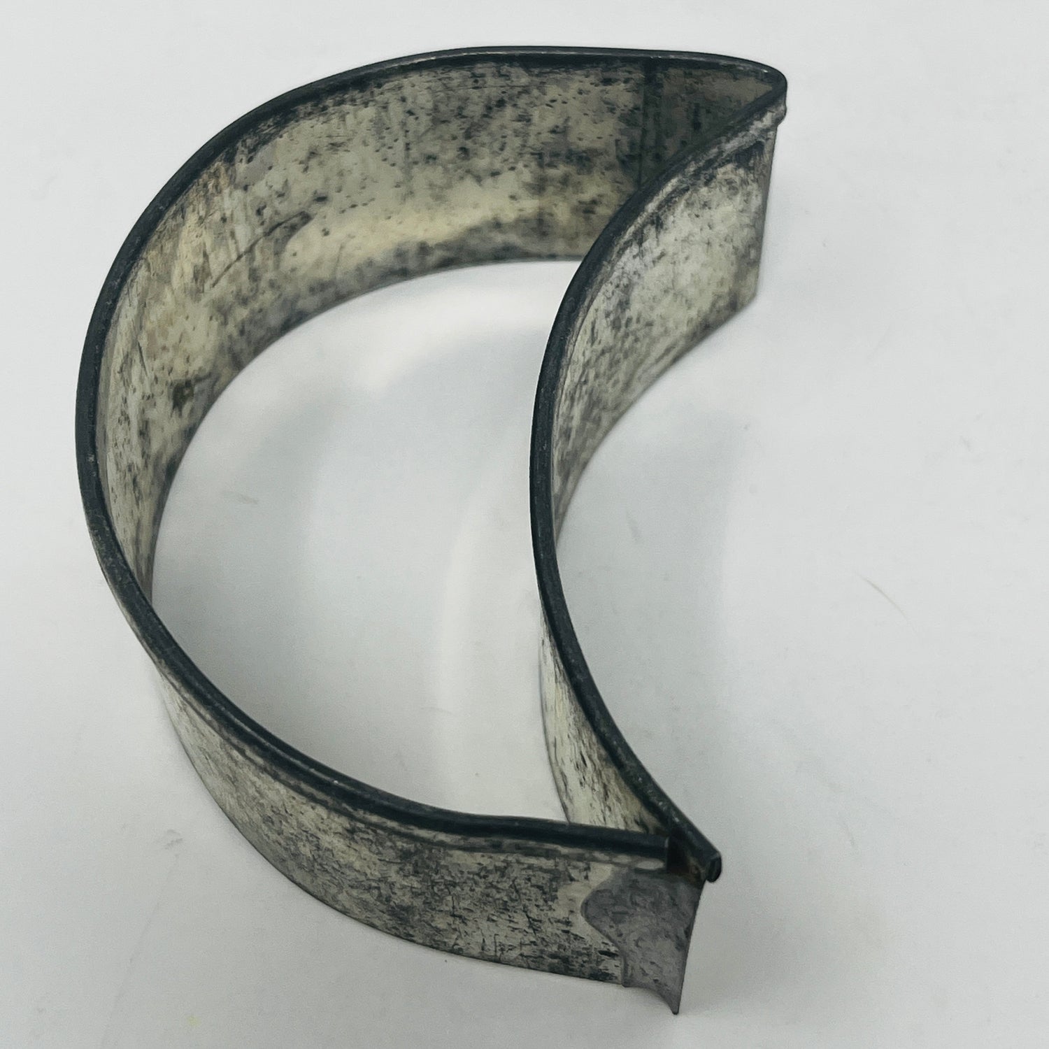 Mid-century metal cookie cutters featuring a large metal handle, showcasing various shapes including celestial designs, emphasizing ease of grip and adaptive use.