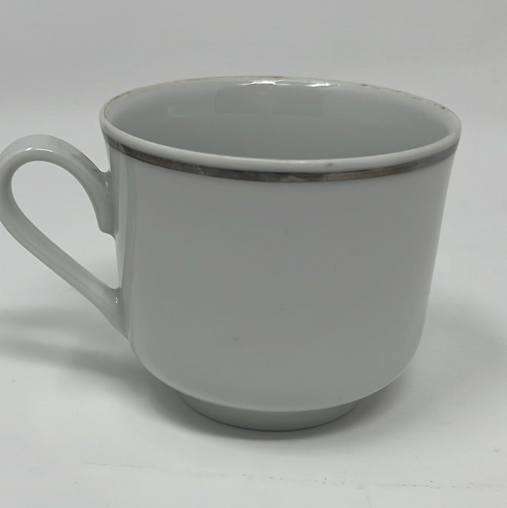 A white ceramic espresso cup with a silver rim, bearing the title ABCO espresso cup with gold trim for United Airlines. Visible wear on the rim.