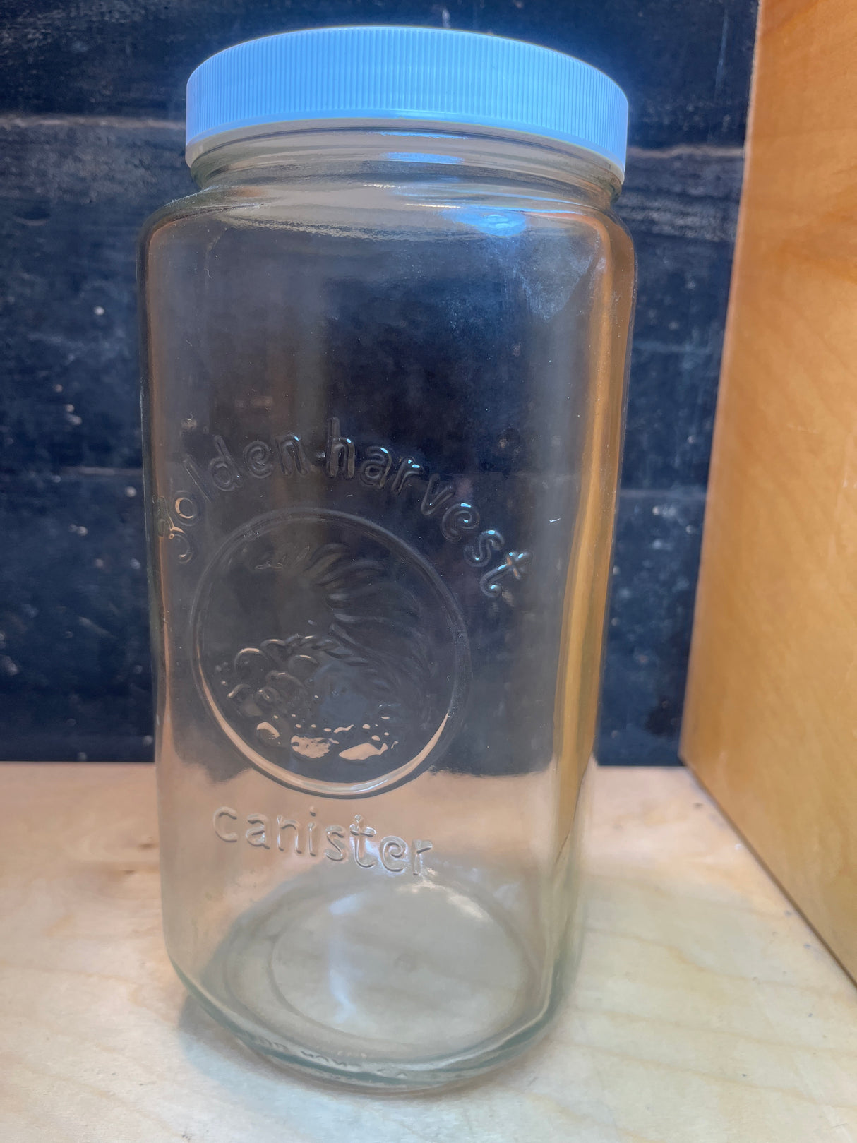 Vintage Golden Harvest glass jar canister with embossed design and screw-on lid, perfect for stylish food storage and kitchen organization.