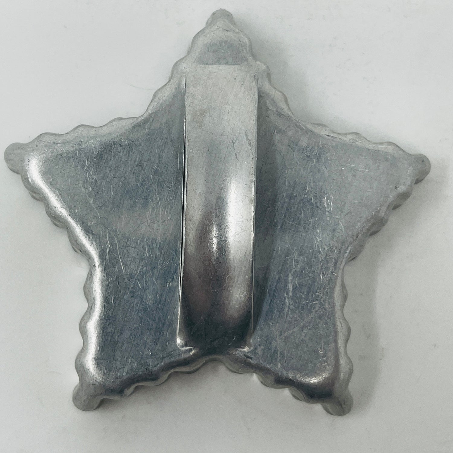 Mid-century metal cookie cutter, star-shaped, featuring a large handle for easy grip; part of a collection that includes celestial and holiday-themed designs.