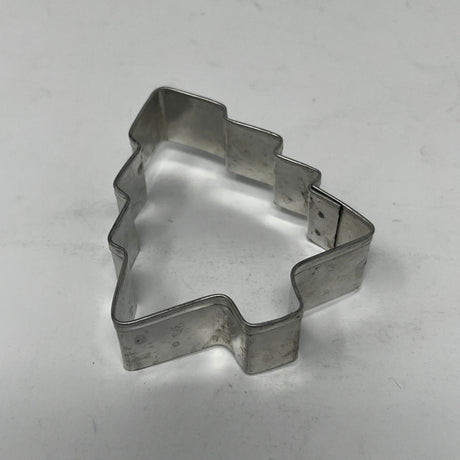Mid-century metal cookie cutter in a tree shape with an easy-grip handle, part of a collection featuring various shapes, including historical designs.