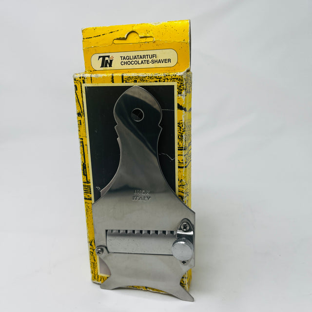 Vintage Italian Tagliatartufi Chocolate Shaver displayed in front of open box, unused. Solidly made with angled blade for easy use. From Spoons Kitchen Exchange.
