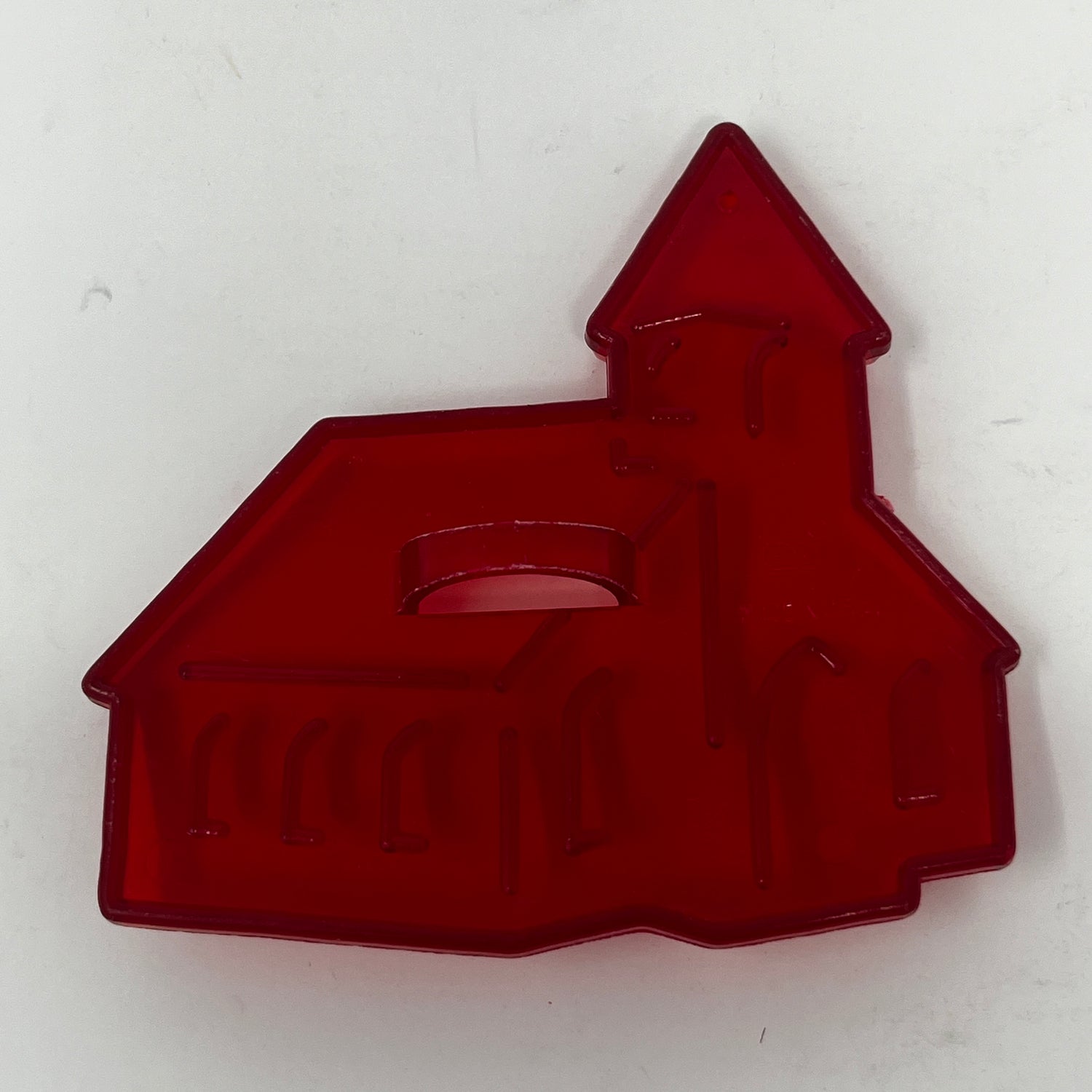 Red plastic mid century cookie cutters, including a church mold and a house design, some with a Crown logo.