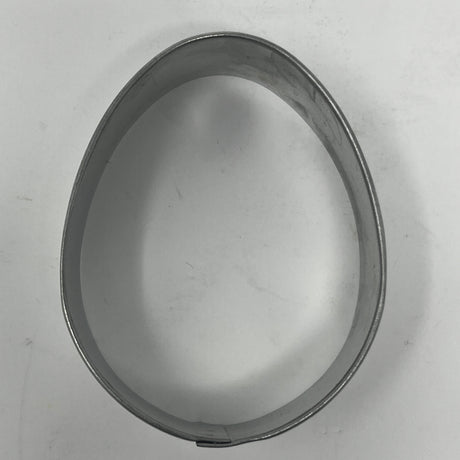 Mid-century metal egg-shaped cookie cutter, part of a collection featuring adaptive handles for easy grip, ideal for creating unique holiday and celestial-themed cookies.