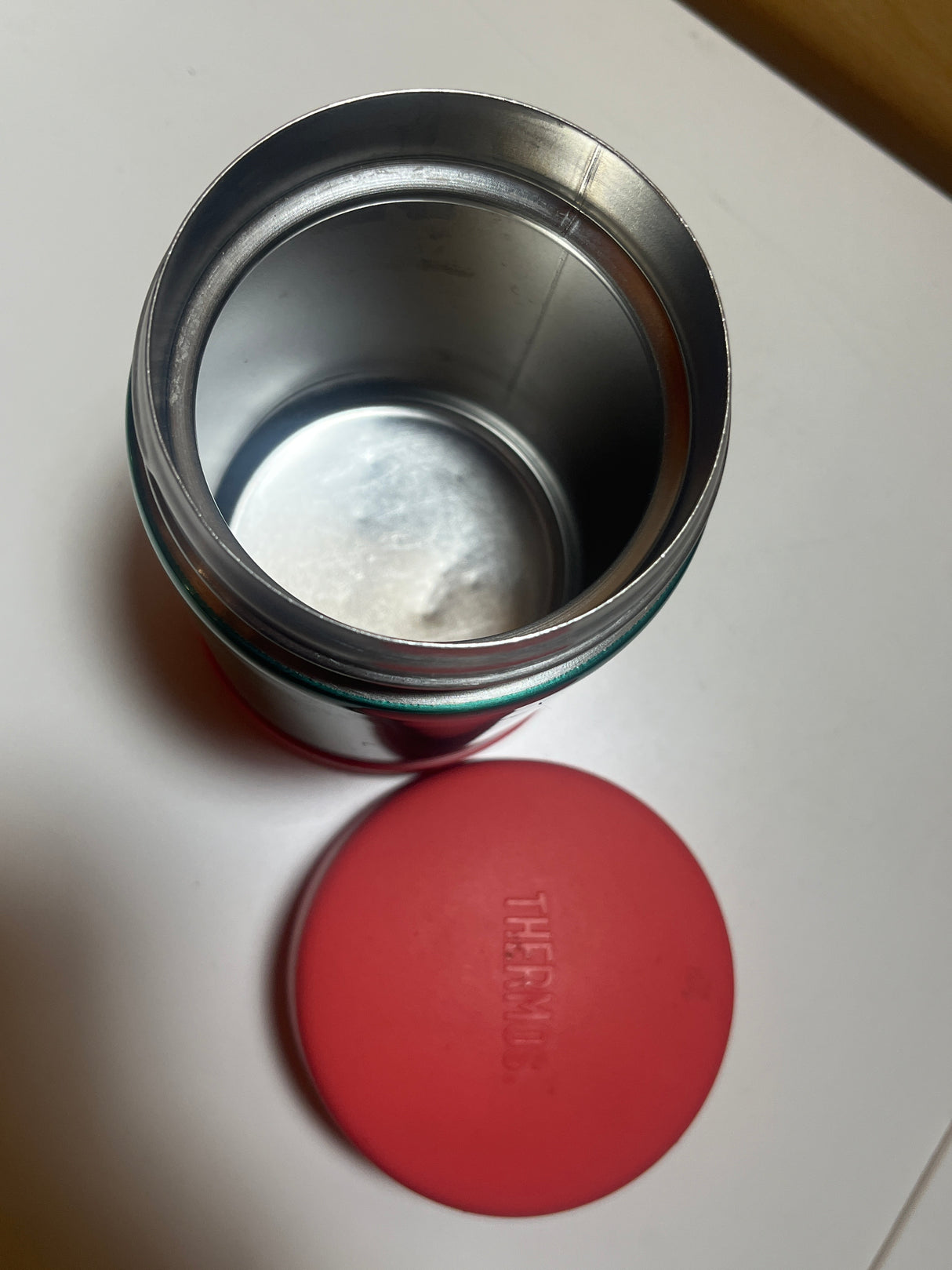 Close-up of a Double-walled pink and green Thermos designed for food and beverages, featuring a circular shape ideal for keeping meals warm on the go.