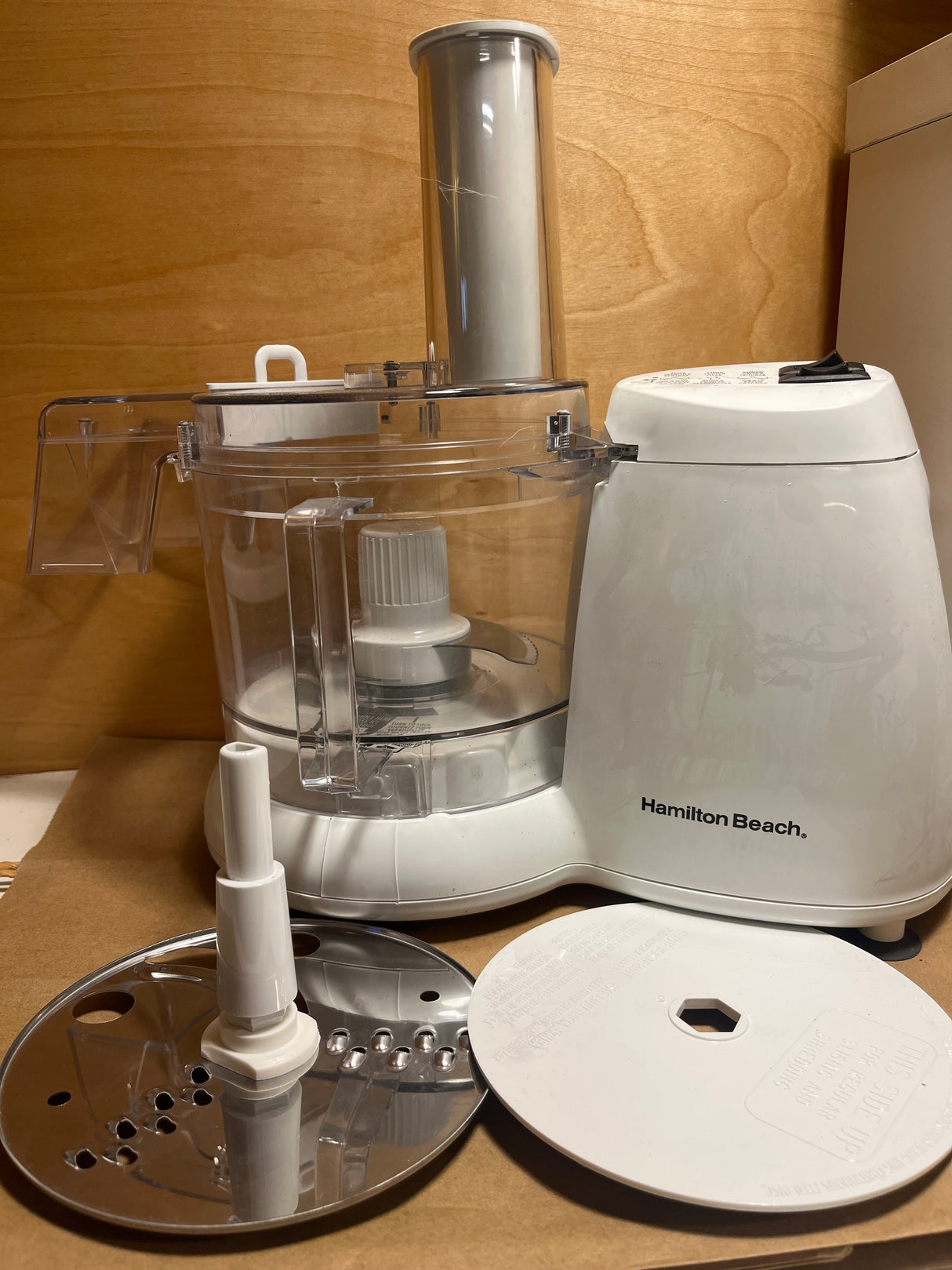 Hamilton Beach Chef Prep 70700 7-cup food processor with work bowl, lid, motor base, shredding disc, drive post, and cover plate visible. Small chip on rim.