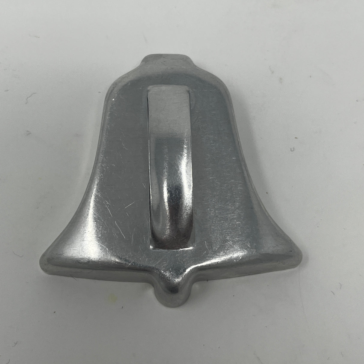 Mid-century metal cookie cutter featuring a silver bell shape with a sturdy metal handle, ideal for easy gripping.