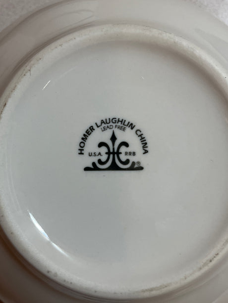 Homer Laughlin China set featuring plates, bowls, saucers, mugs, and creamer, showcasing classic dinnerware design and elegant craftsmanship.