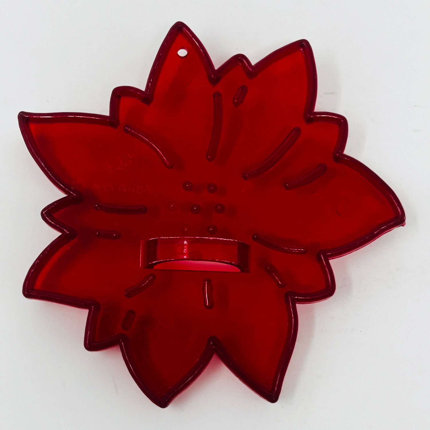 Red plastic mid century cookie cutters, one shaped like a leaf, with a red light and a blood sample close-up.