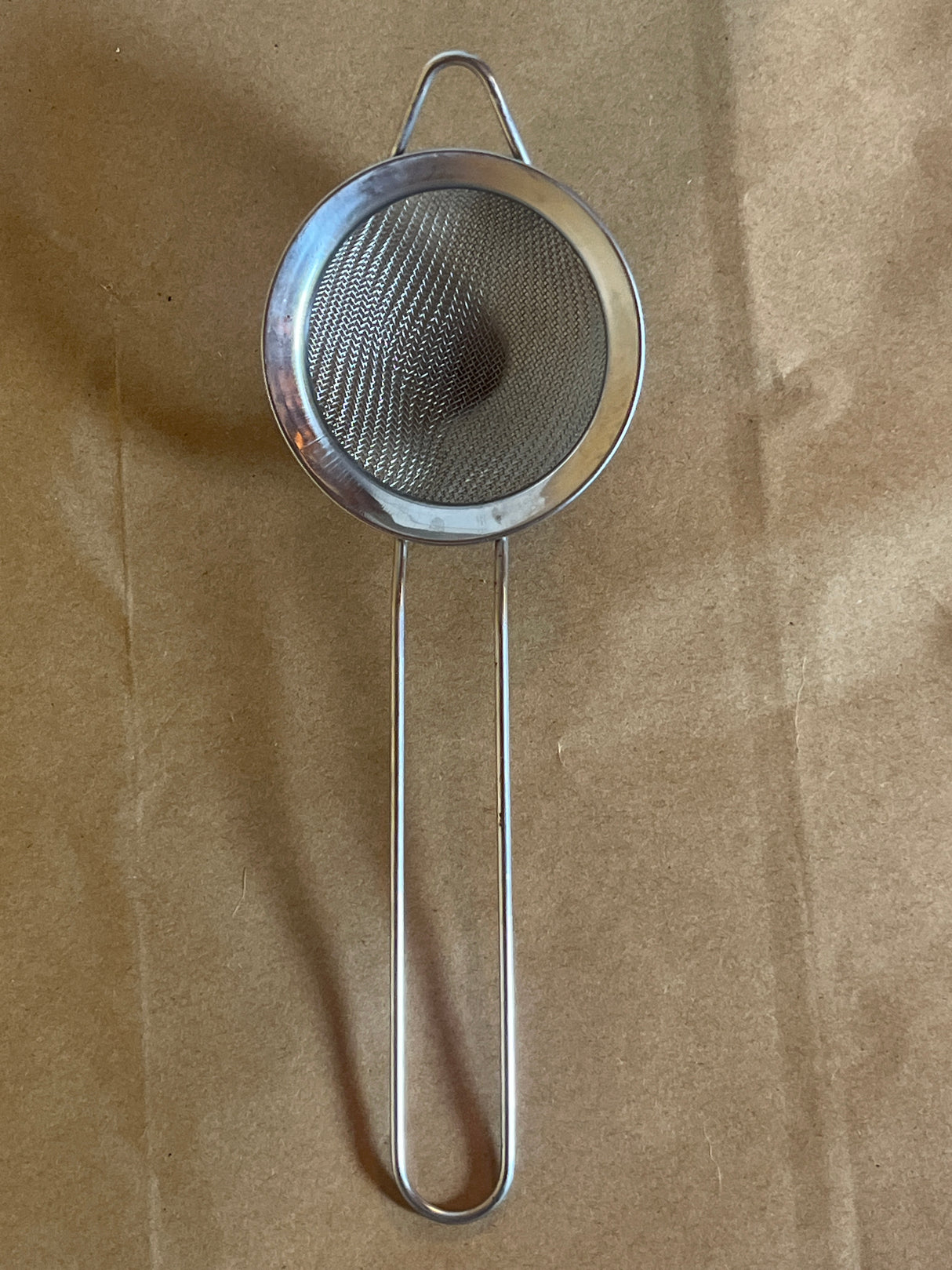 Stainless steel mesh strainer with loop handle, 2 inch, featuring a fine mesh for straining teas and small tasks, includes a hanging ear for easy use.