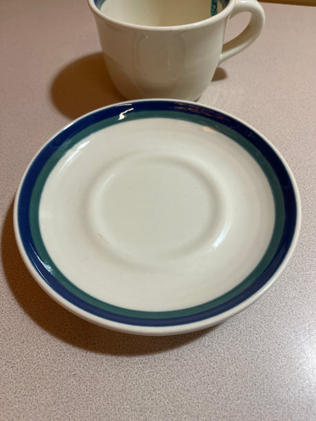 Pfaltzgraff Ocean Breeze stoneware set includes plates, bowls, and mugs with raised rims and blue-green stripes; some mugs show light crazing marks.