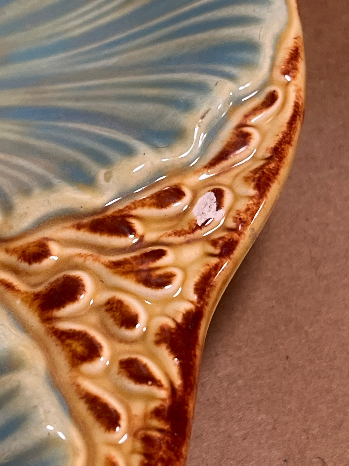 RARE French majolica oyster plate with a blue-green leaf-vein pattern, brown-tan border, and a small chip exposing white clay.