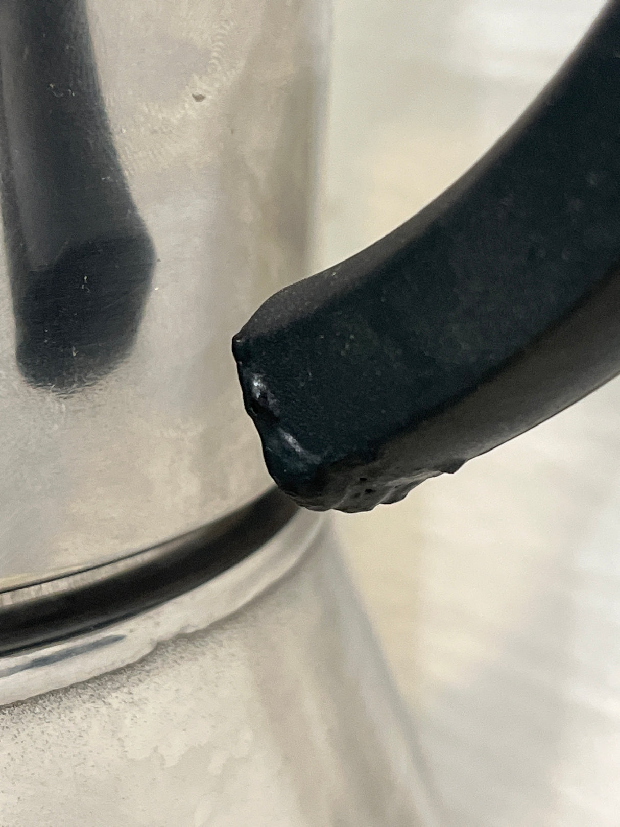 Close-up of VEV Vigano Carioca 6-cup stainless steel stovetop espresso pot with a black handle showing slight wear, highlighting its elegant design and craftsmanship.