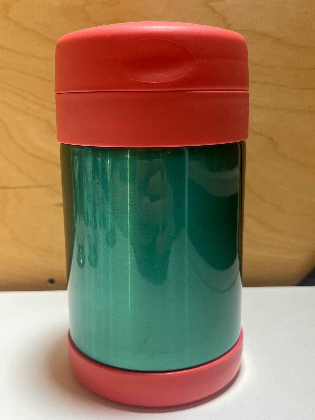Double-walled pink and green Thermos with red lid, ideal for keeping meals warm. Perfect for transporting coffee, soup, or leftovers on the go.