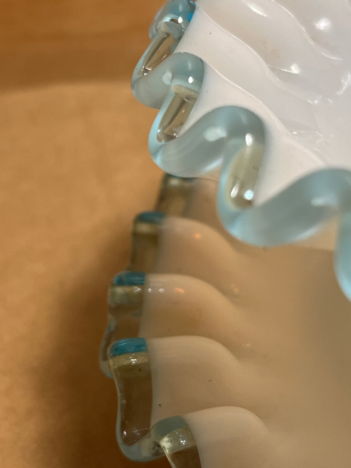 Close-up of Bowl n plate hair clip's interlocking teeth and metal spring hinge, showcasing a detailed view of its unique design and construction.