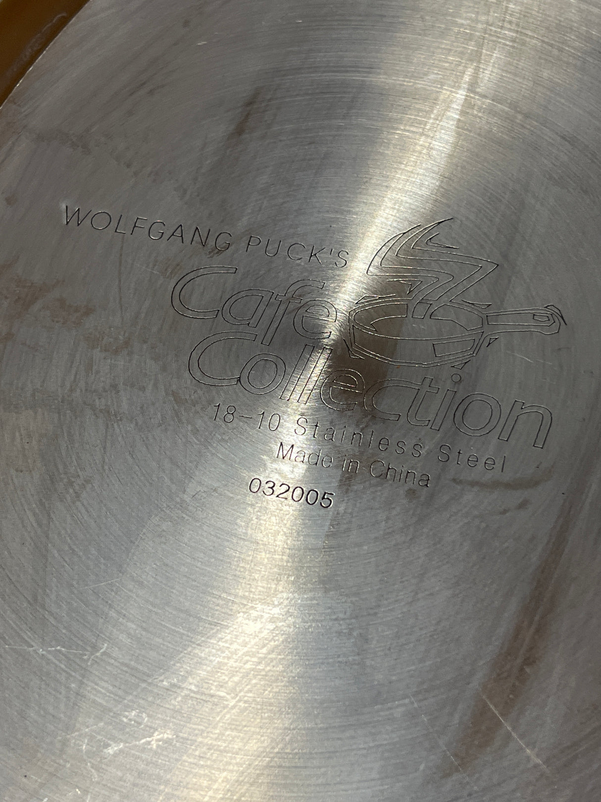 Wolfgang Puck Bistro Collection 18-10 stainless steel oval fish pan's base, displaying stamped branding, Made in China, and model number 032005, missing its original glass lid.