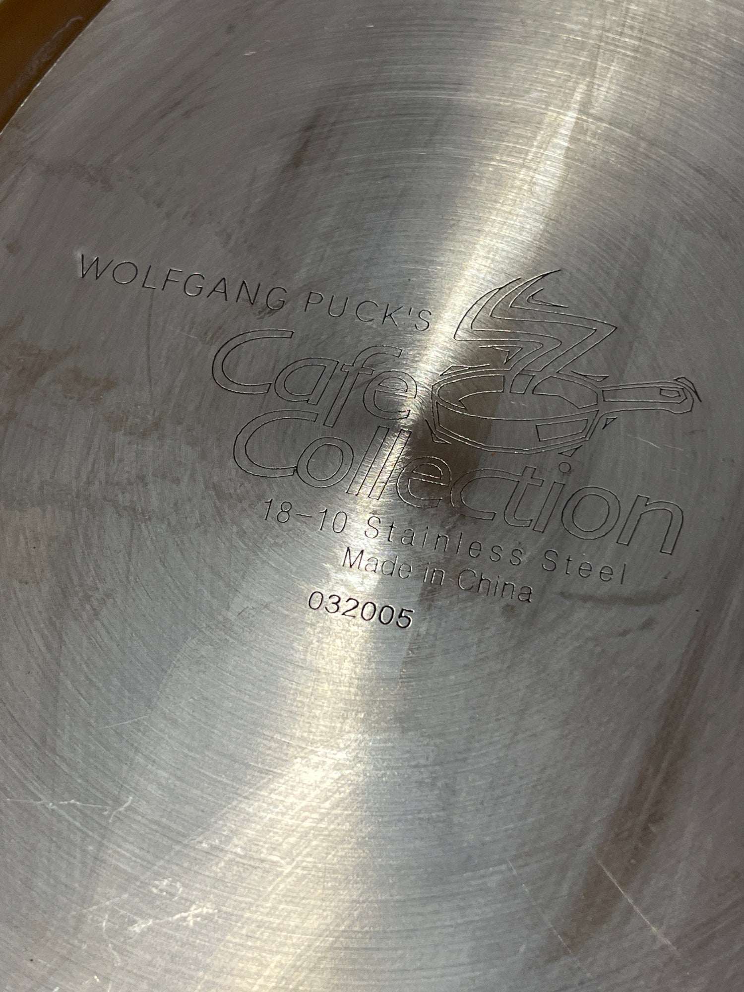 Wolfgang Puck Bistro Collection 18-10 stainless steel oval fish pan's base, displaying stamped branding, Made in China, and model number 032005, missing its original glass lid.