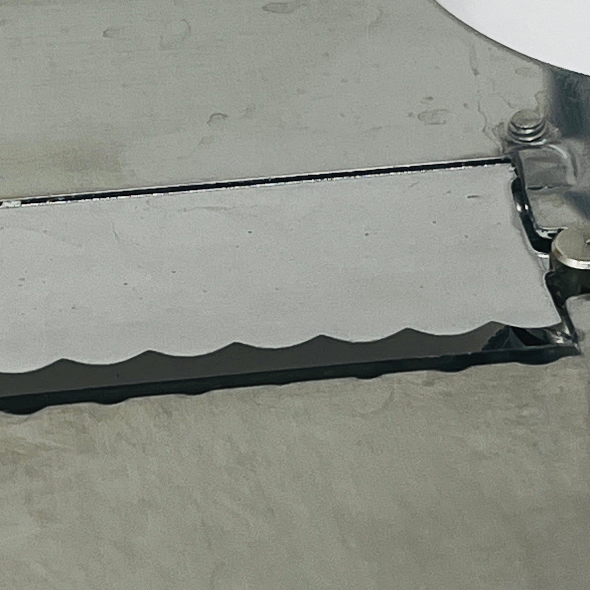 Tagliatartufi Chocolate Shaver closeup of metal plate with screws, Italian-made vintage tool for chocolate or truffles, angled blade for ease of use. From Spoons Kitchen Exchange.