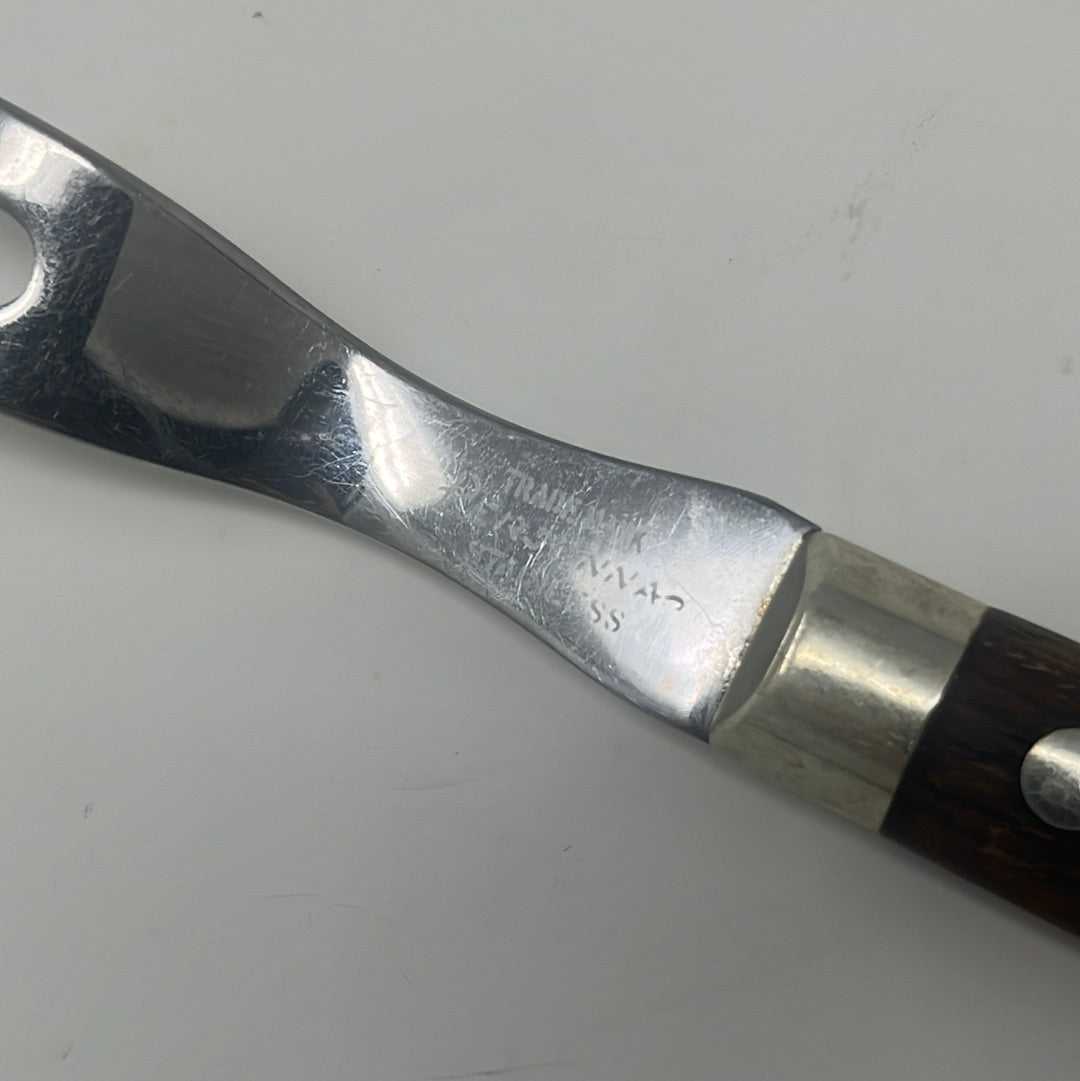 A vintage stainless steel 2-prong carving fork with a wooden handle, ideal for slicing roast meats. Close-up of a classic hand tool from the 1950s.