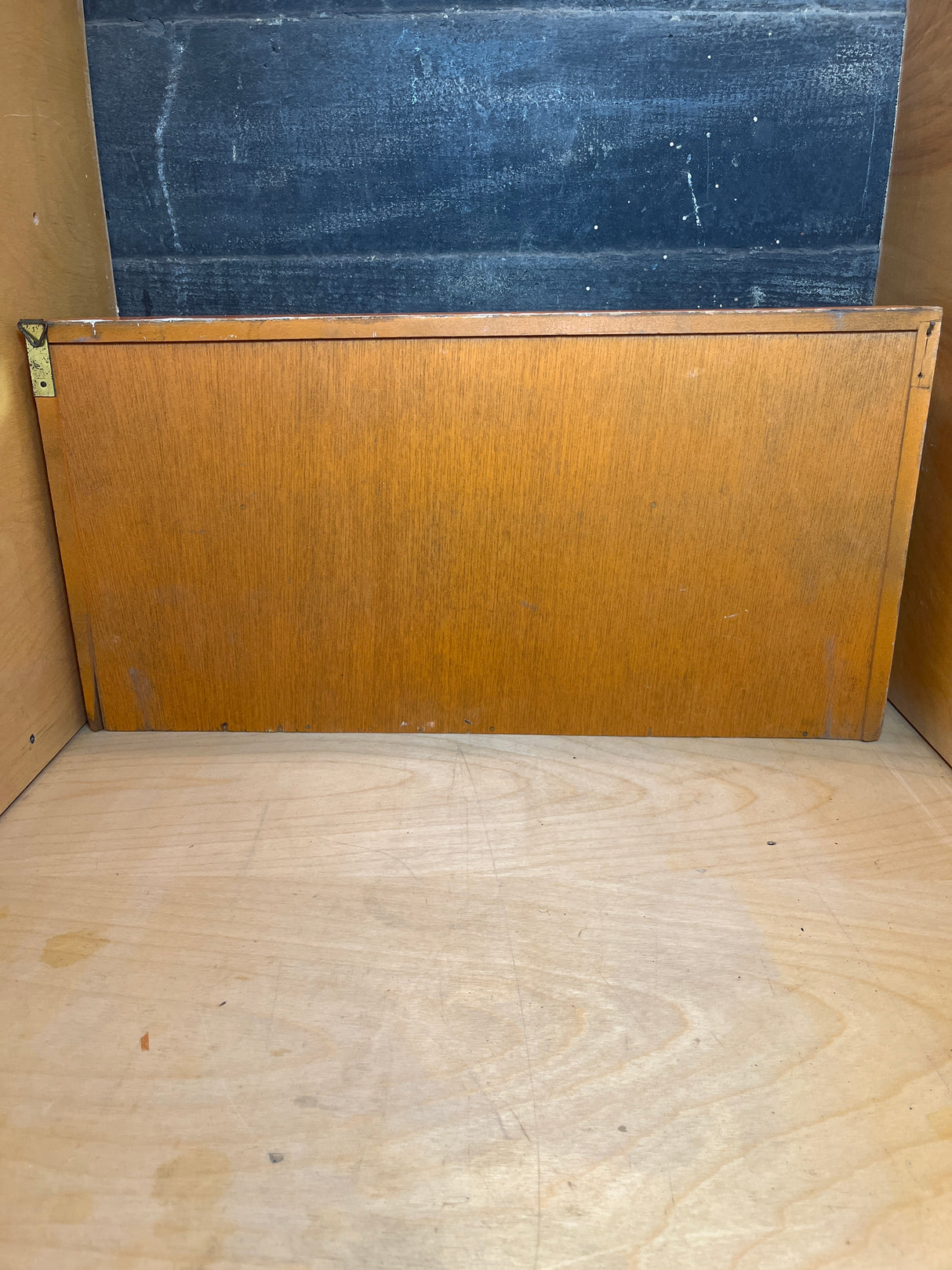 Empty wooden cubby designed for the Funky floral wooden spice rack, featuring a light plywood shelf, medium-brown panel, and dark surface. No jars included.