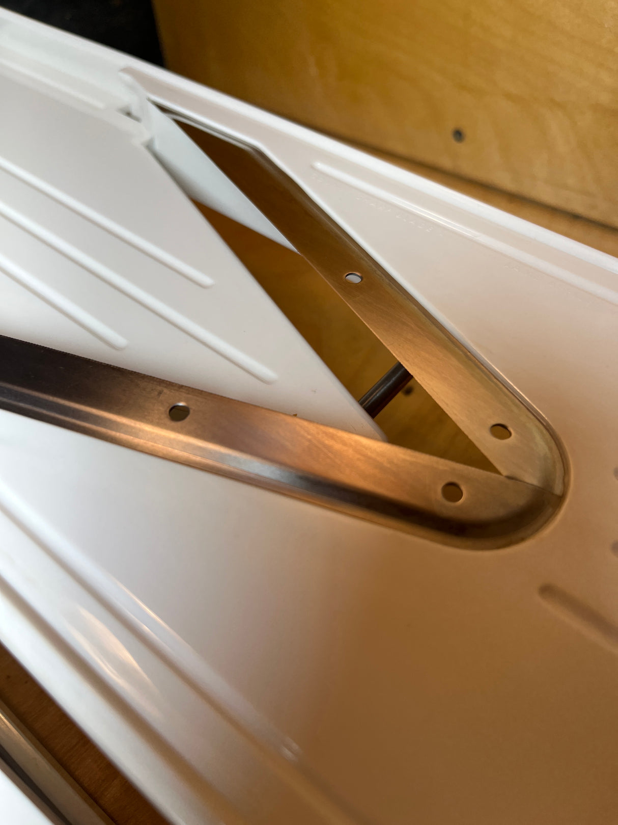 Close-up of Zyliss Easy Slice mandolin's ribbed plastic panel with a folding V-shaped steel bracket, highlighting its durable hinge mechanism for secure slicing.