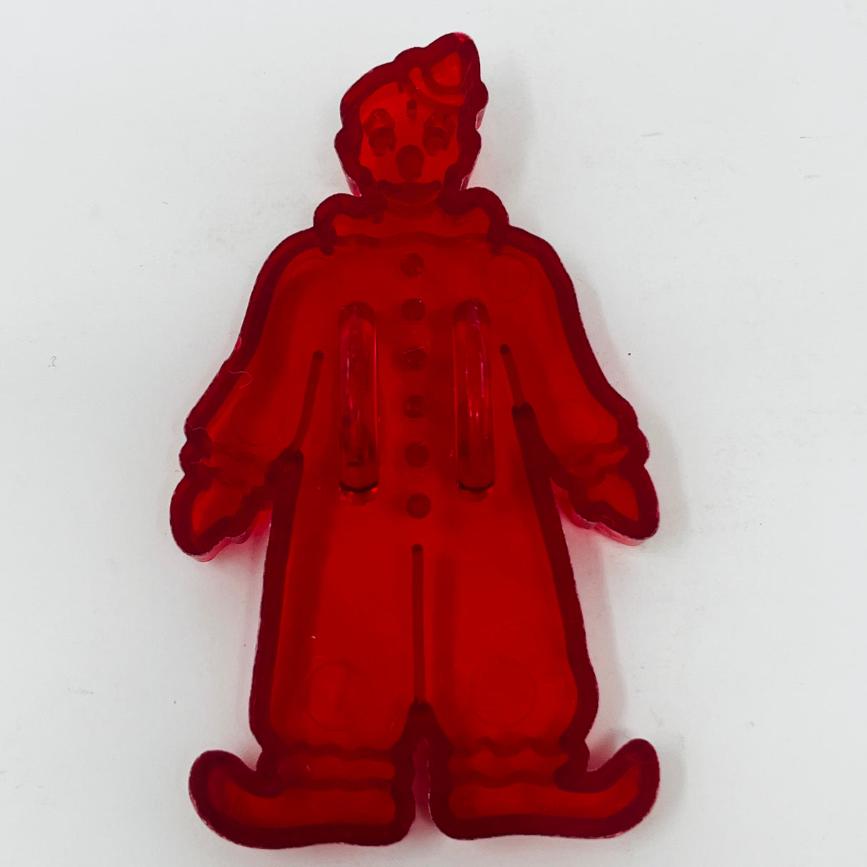 Red plastic mid century cookie cutters, one with a Crown logo, one with a face mold, and one with transparent objects.