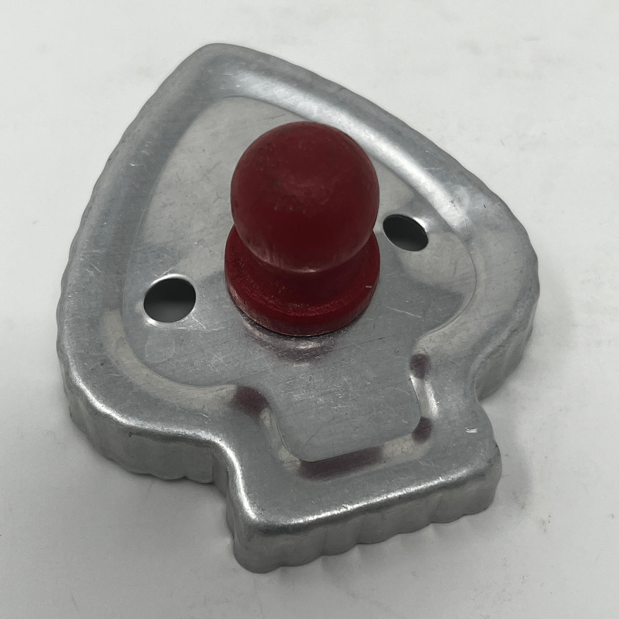 Mid century metal cookie cutter featuring a distinctive red knob handle, designed for easy gripping. Part of an adaptive collection with historical and celestial shapes.