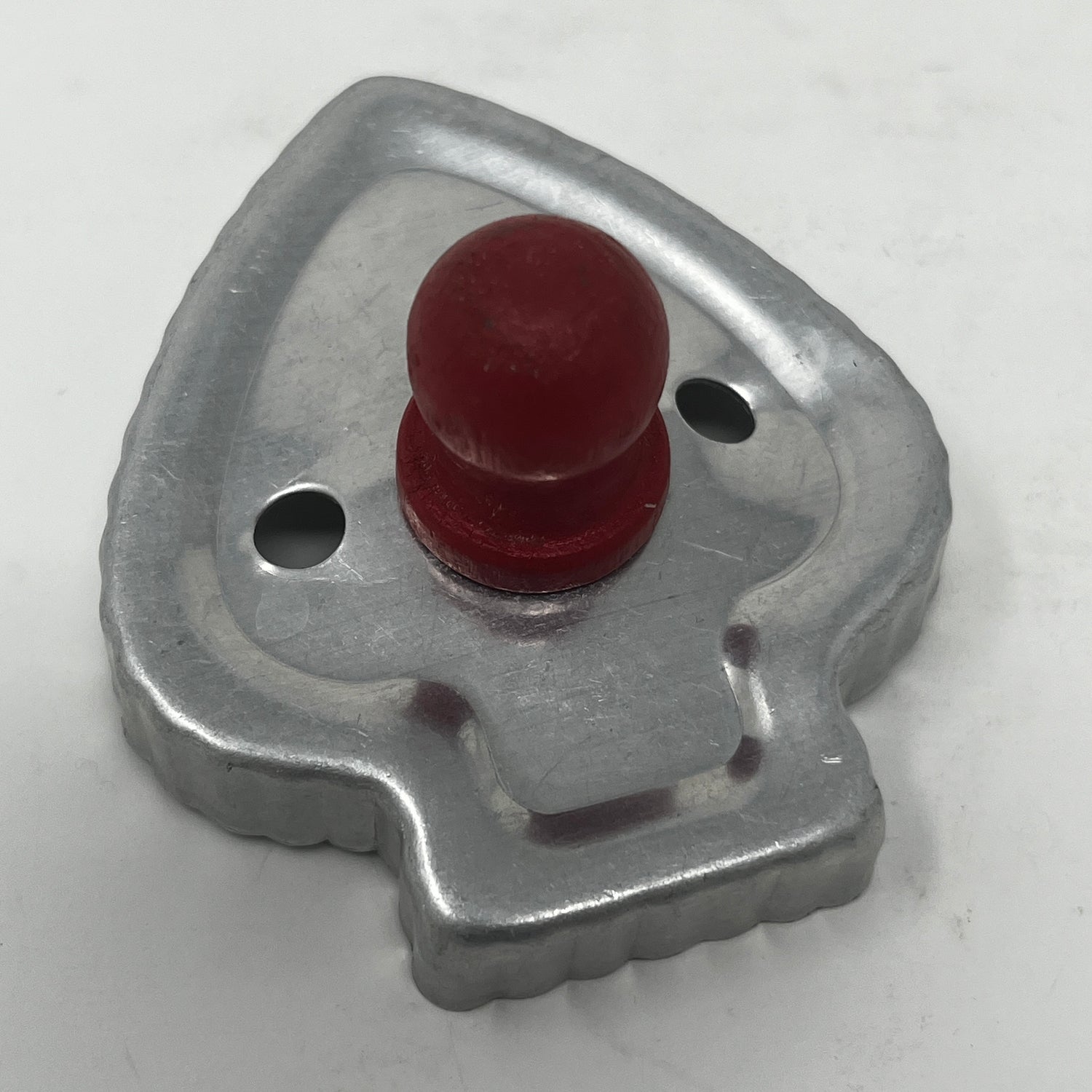 Mid century metal cookie cutter featuring a distinctive red knob handle, designed for easy gripping. Part of an adaptive collection with historical and celestial shapes.