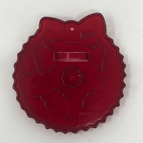 Red plastic mid century cookie cutters, one with a cat face, another with a flower shape, and a white line design.