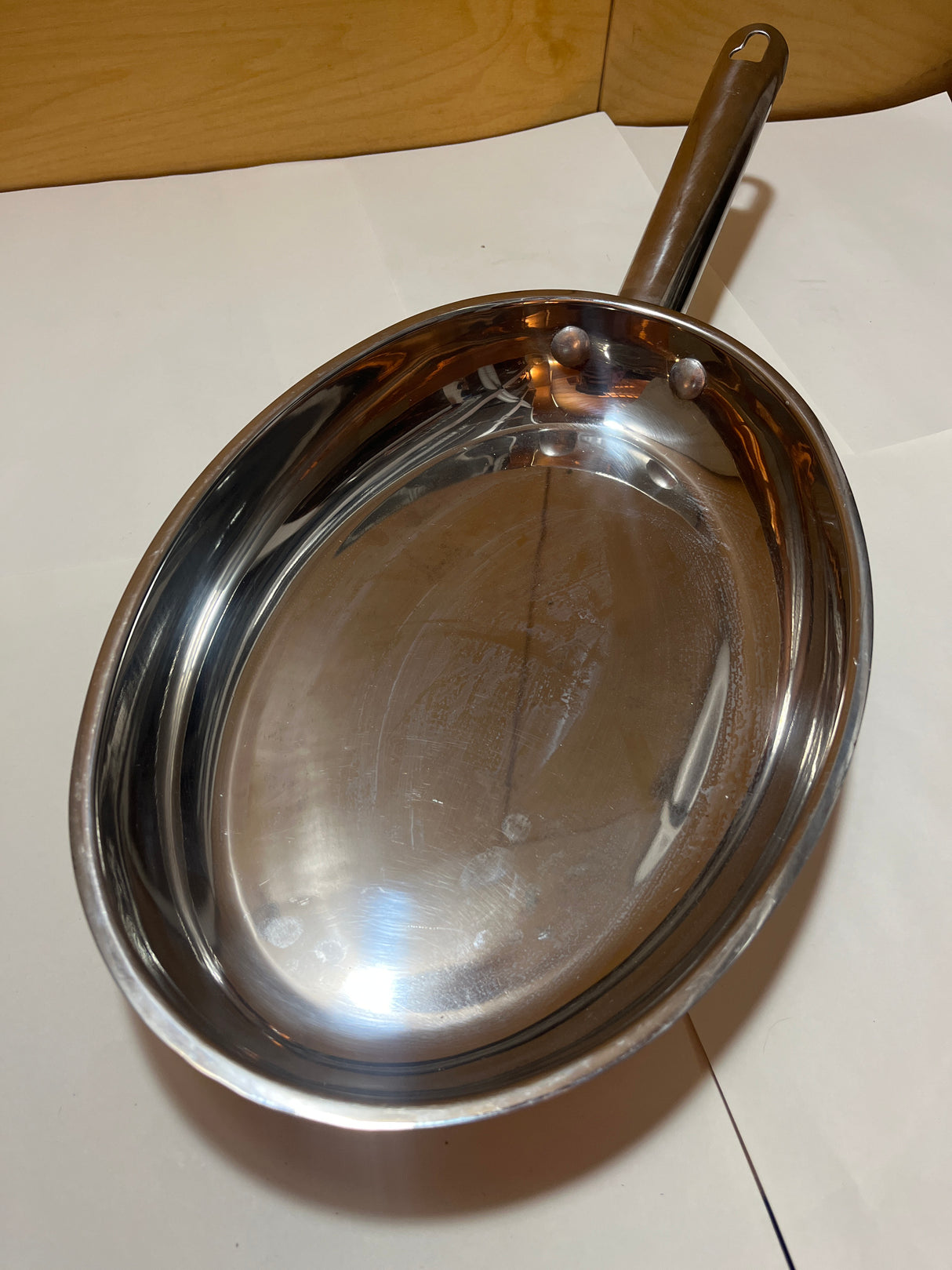 Wolfgang Puck Bistro Collection 18-10 stainless steel oval fish pan displayed with a long handle and visible rivets, missing its original glass lid.