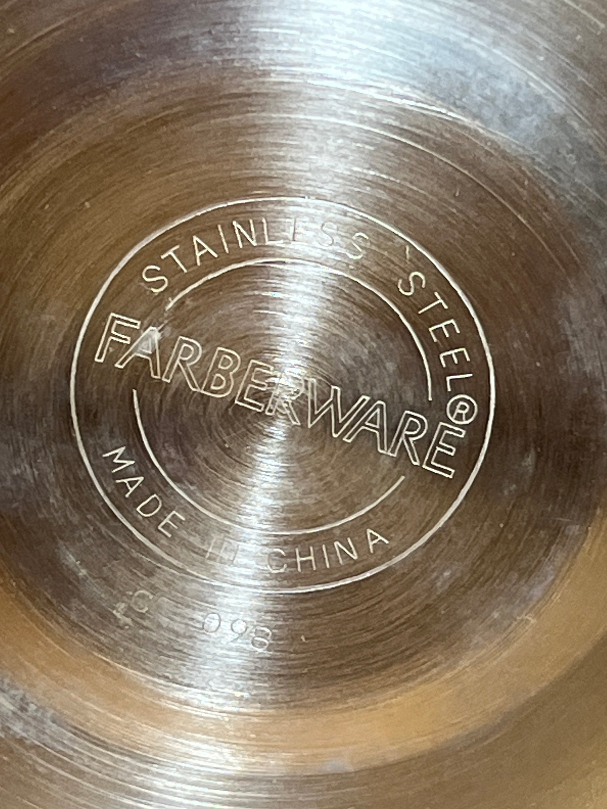 Base of Farberware 2.5 quart Whistling Tea Kettle, showing stainless steel with concentric rings and markings, including STAINLESS STEEL and model C-098.