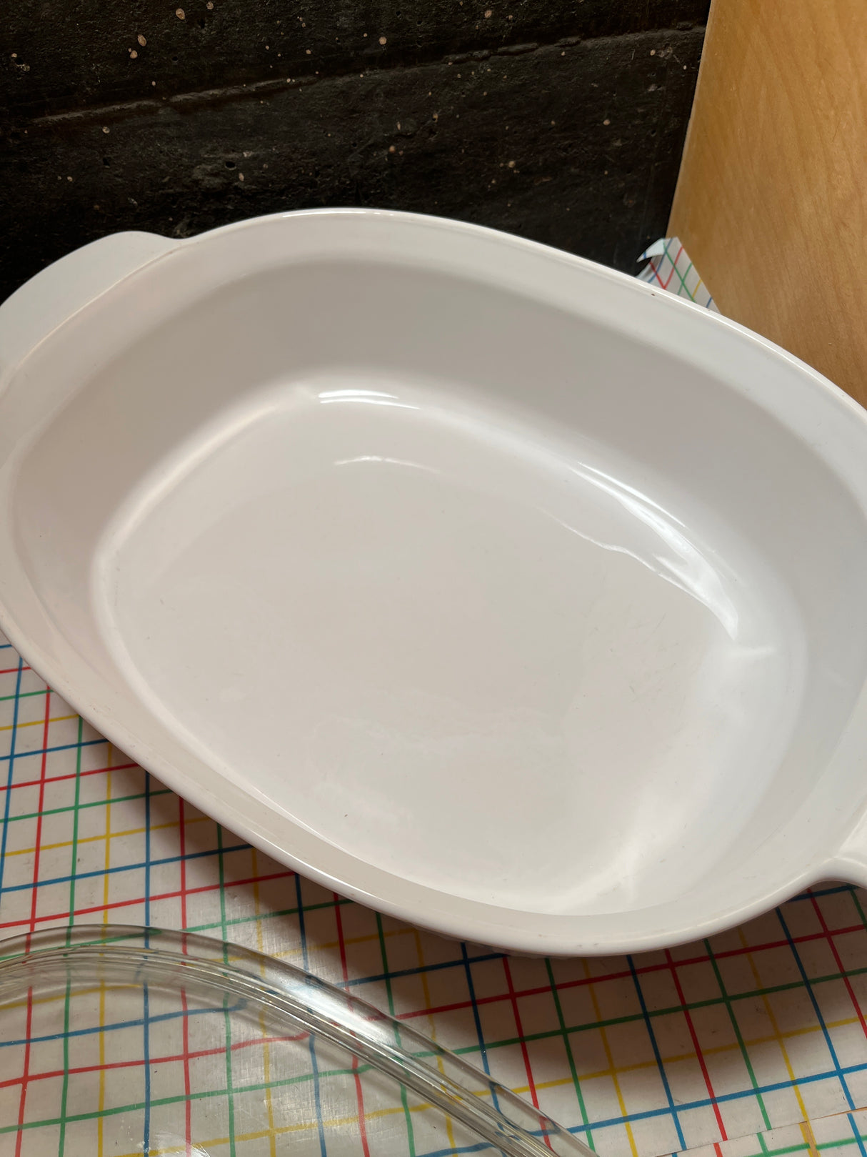 4-liter oval casserole dish with lid - PYREX Corning Ware French White F-14-B on a patterned mat, showcasing its oven-to-table versatility.