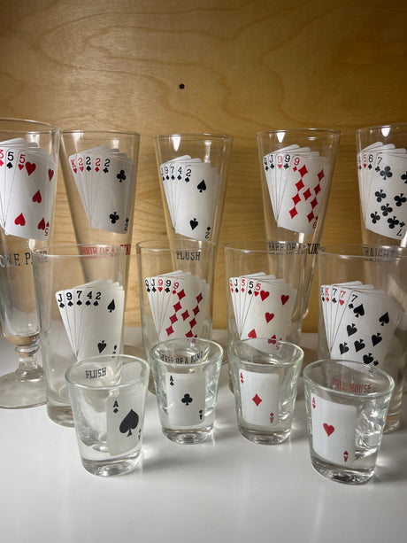 RARE 1960’s MCM poker-themed drinkware set featuring tall and shot glasses, each displaying unique five-card poker hands like Full House and Straight.