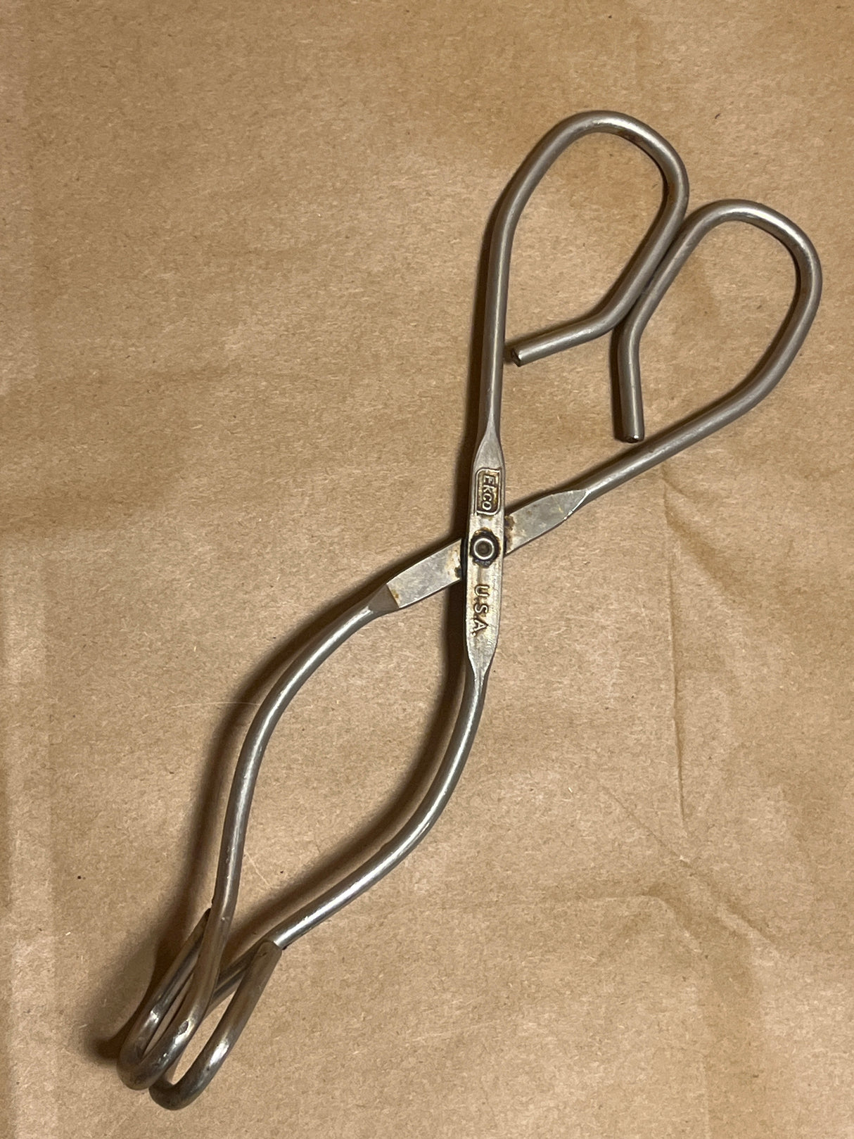 EKCO stainless steel kitchen tongs with looped handles and jaws for secure food handling, ideal for grilling and frying, showcasing vintage design and durability.