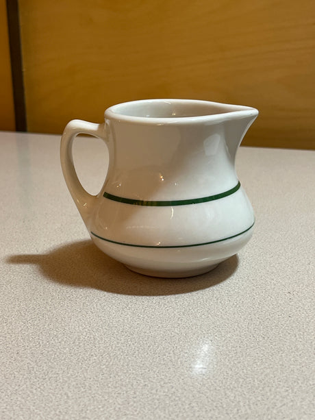 Homer Laughlin China set displaying plates, bowls, saucers, mugs, and a creamer, elegantly arranged, highlighting their classic design and cohesive style.