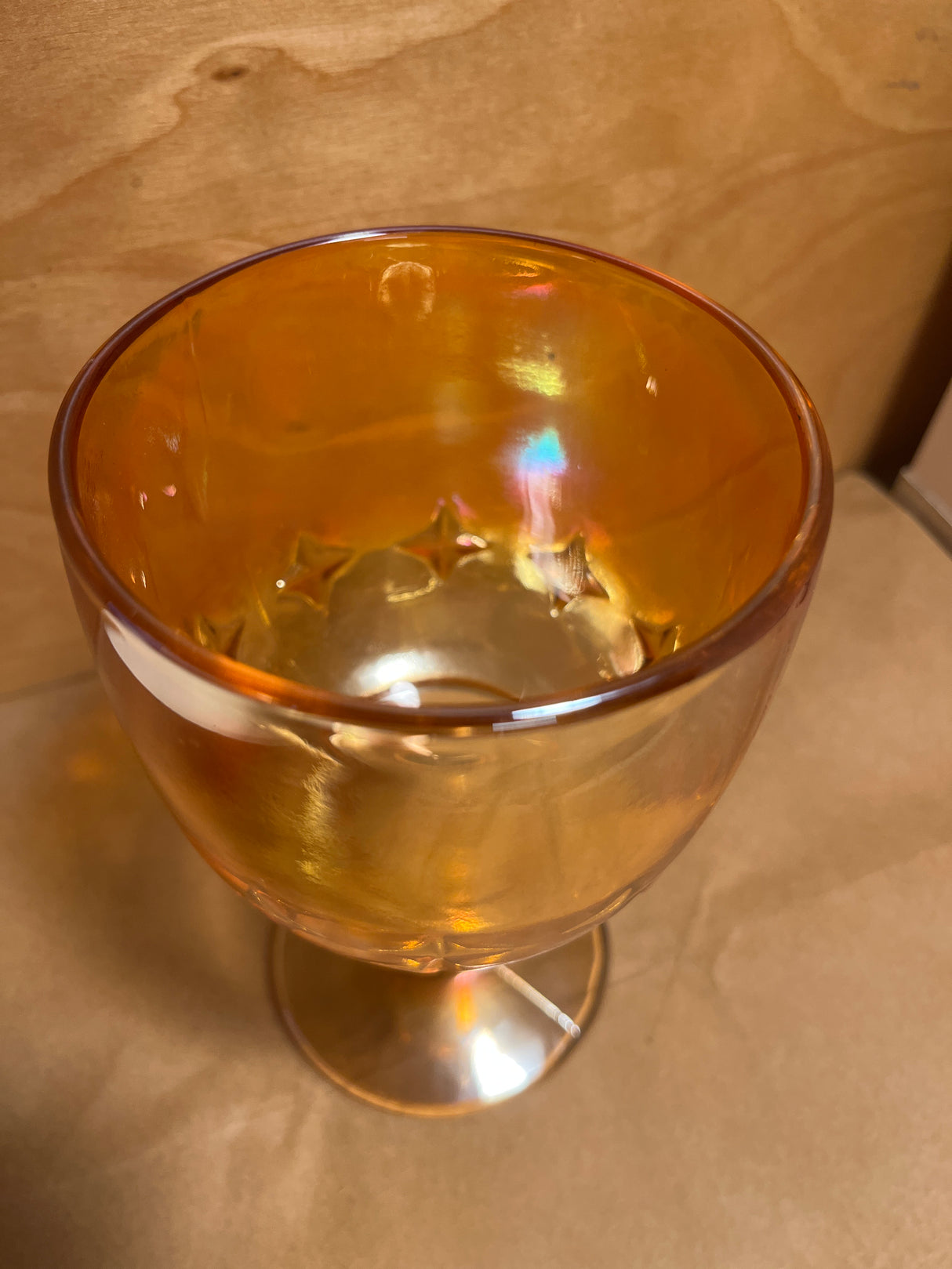 Bartlett Collins Star Marigold Carnival goblet featuring iridescent amber-orange glass with star-shaped embossing around the bowl, set against a simple background.