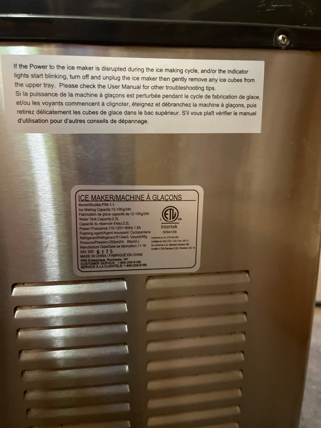 Portable countertop ice maker - Hamilton Beach, showing rear labels with instructions and specifications, including ETL certification, model PIM-1-1, and power details.