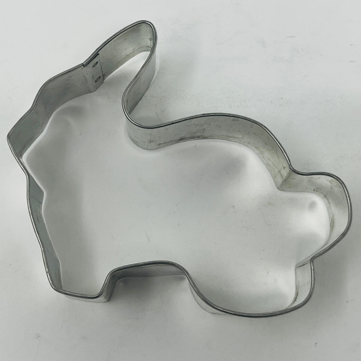 Mid-century metal cookie cutter shaped like a rabbit, ideal for adaptive use with a large handle, reflecting vintage kitchenware design.